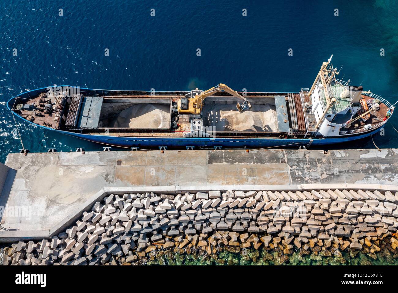 Marine works construction equipment and machinery, aerial drone view, Sand loading machine on an industrial ship moored at the dock, at Korissia port, Stock Photo