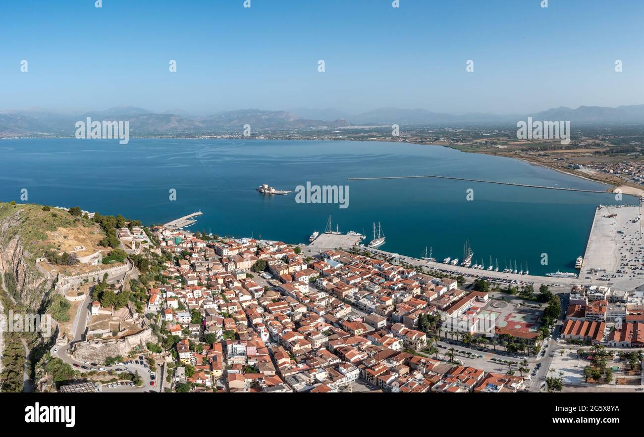 Greece, Nafplio city and Bourtzi, Aerial drone view. Peloponnese old town cityscape, and Venetian water fortress at the entrance of the harbour. Blue Stock Photo