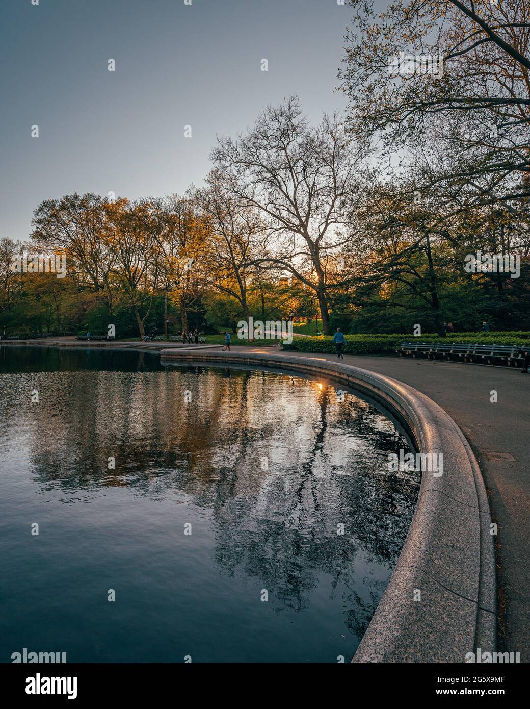A body of water with trees around it - the Conservatory Water at sunset Central Park, Manhattan, New York Stock Photo