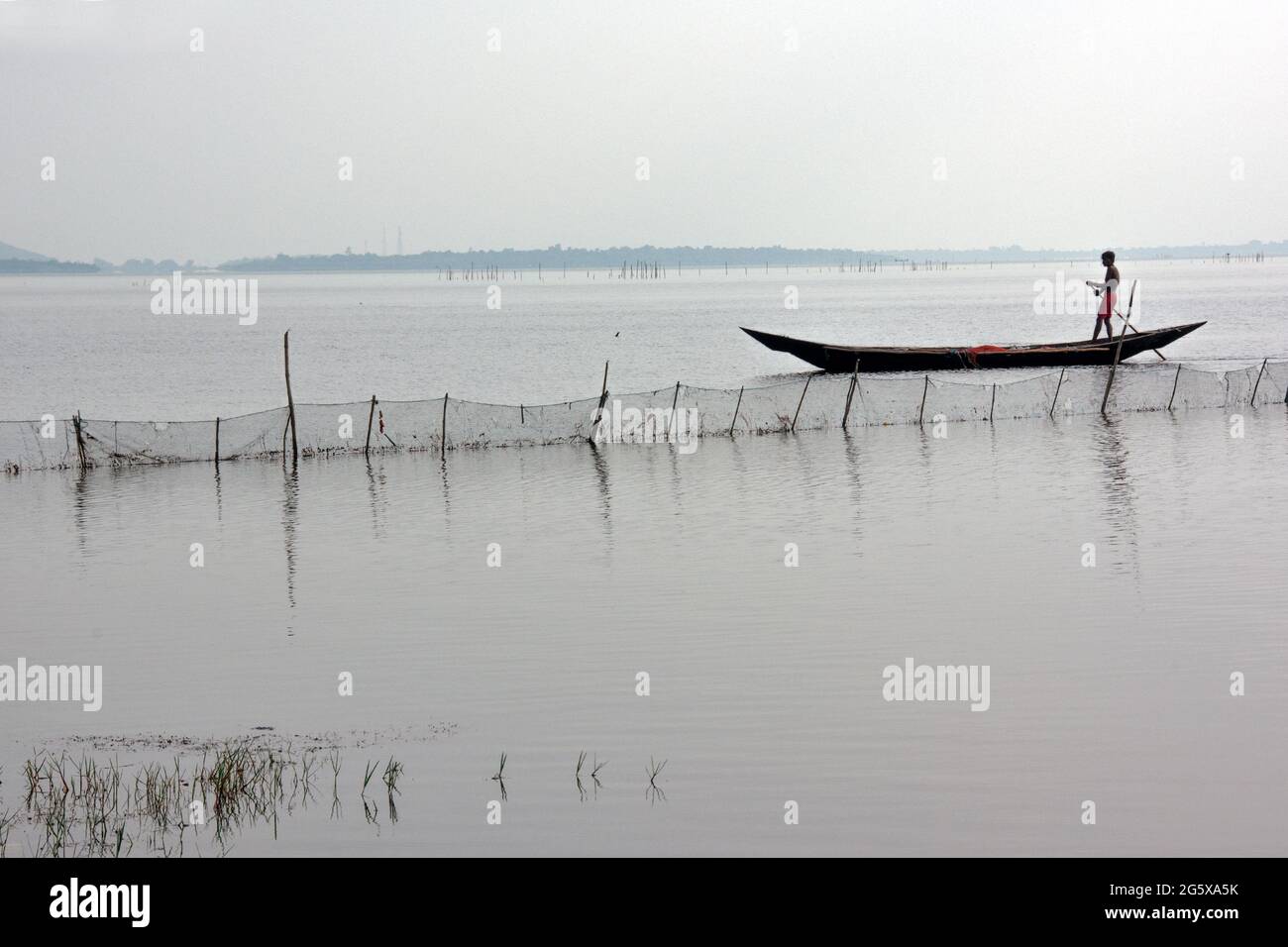 Picture of Chilka Lake in Rambha, Odisha. A fisherman is going fishing in the lake with his boat. Stock Photo