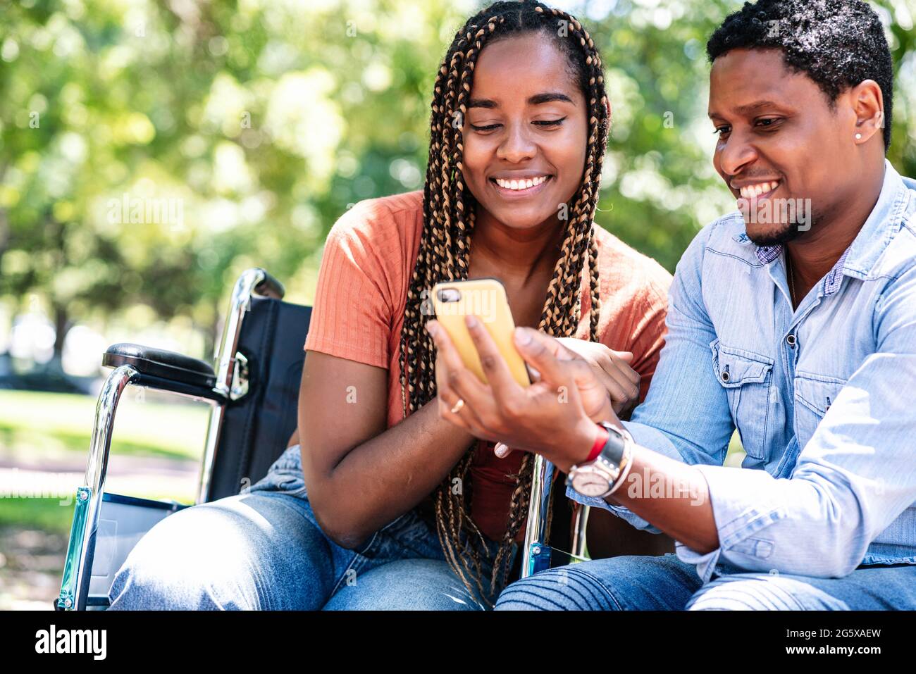Woman in a wheelchair using a smartphone with her boyfriend Stock Photo ...