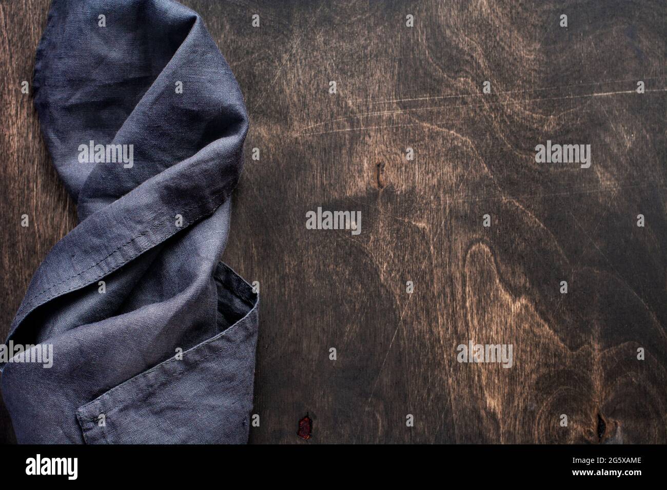 Dark brown wood texture with cotton kitchen napkin or towel over . Abstract background.Copy space background Stock Photo