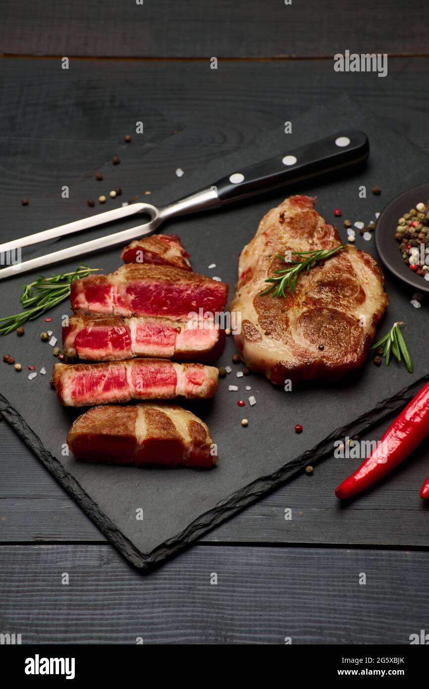 Grilled sliced roated beef steaks on stone serving cutting board Stock ...