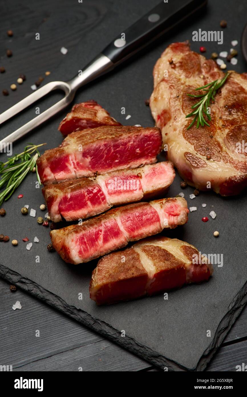 Grilled sliced roated beef steaks on stone serving cutting board Stock ...