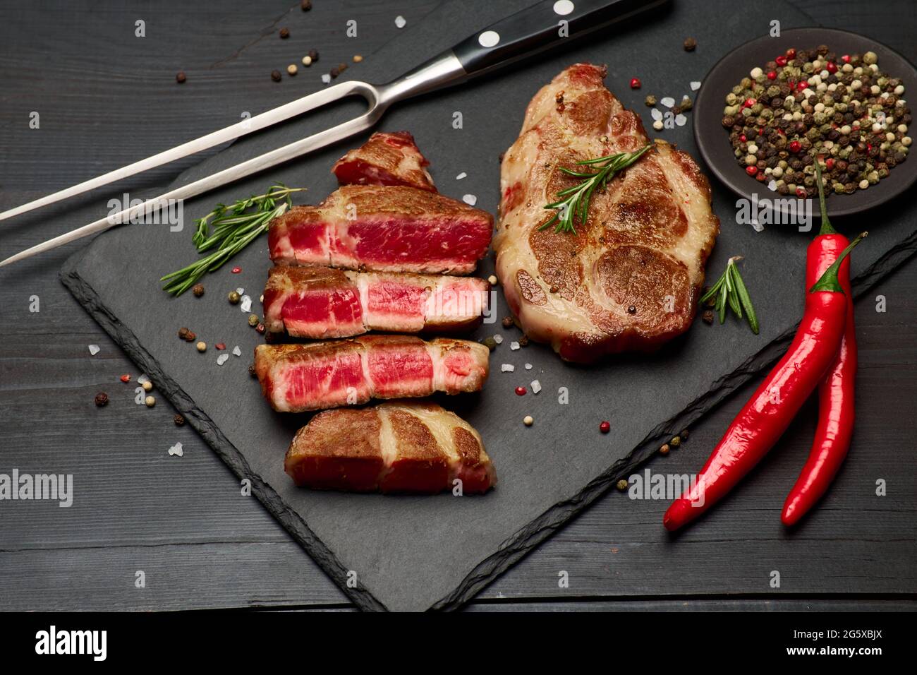 Grilled sliced roated beef steaks on stone serving cutting board Stock ...