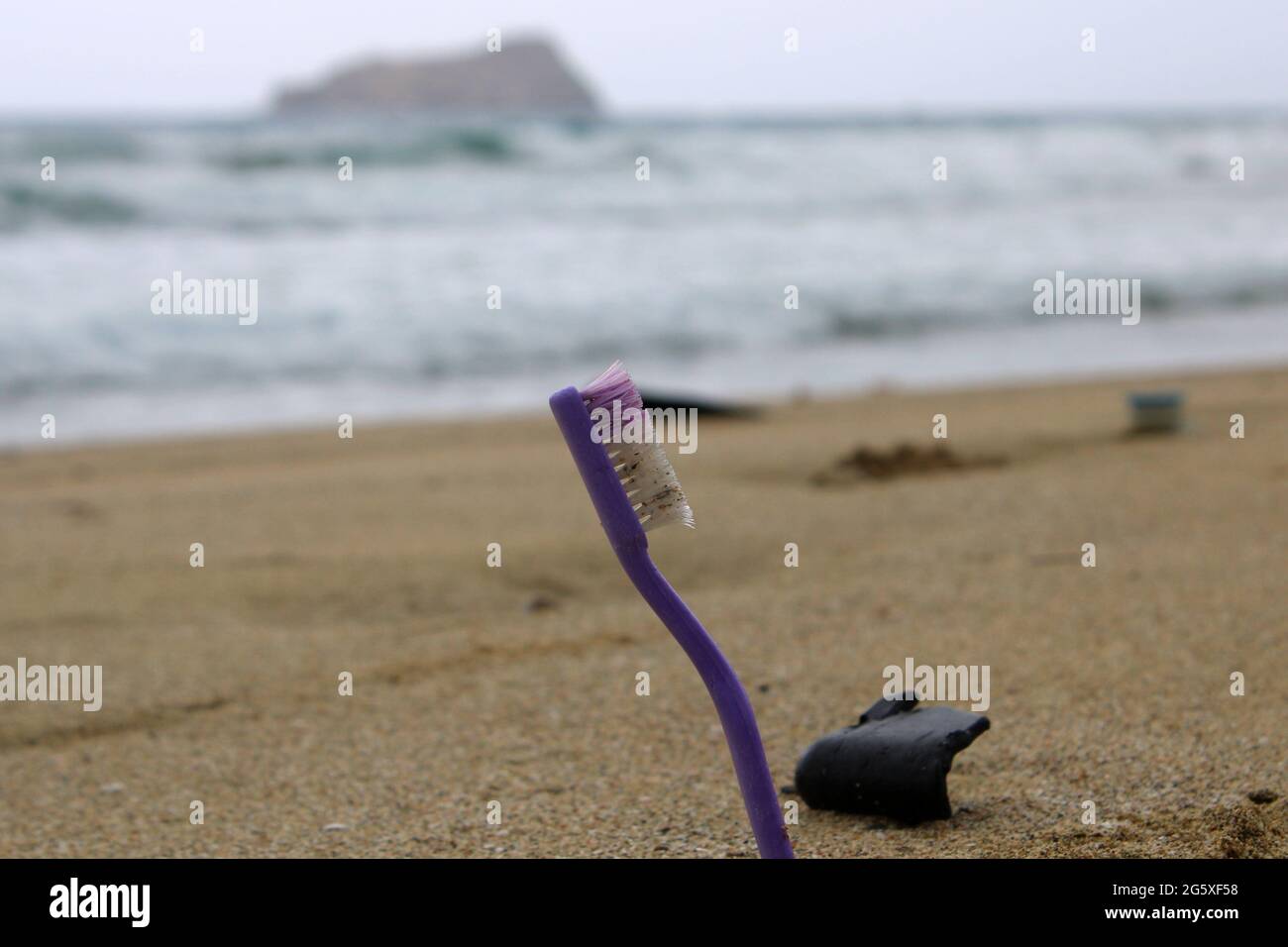 toothbrush as part of all the garbage on the beach. Stock Photo