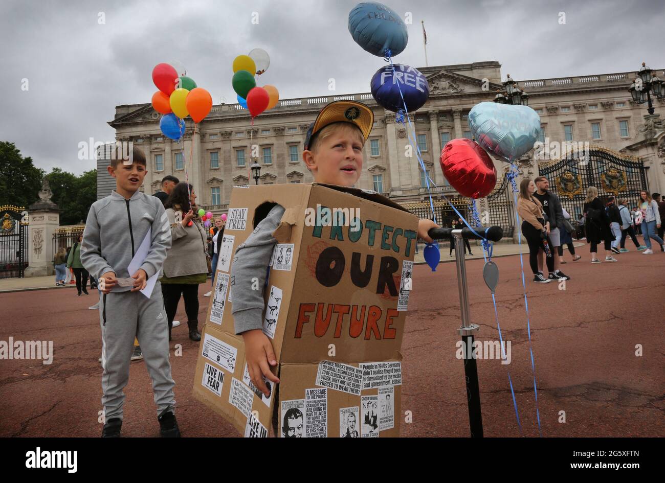 London, UK. 19th June, 2021. A young protester wearing a box for a jacket covered with freedom stickers and slogans takes part during the demonstration.Children and parents held a protest against forced vaccination for children, lockdown restrictions and no masks and testing in schools. (Photo by Martin Pope/SOPA Images/Sipa USA) Credit: Sipa USA/Alamy Live News Stock Photo