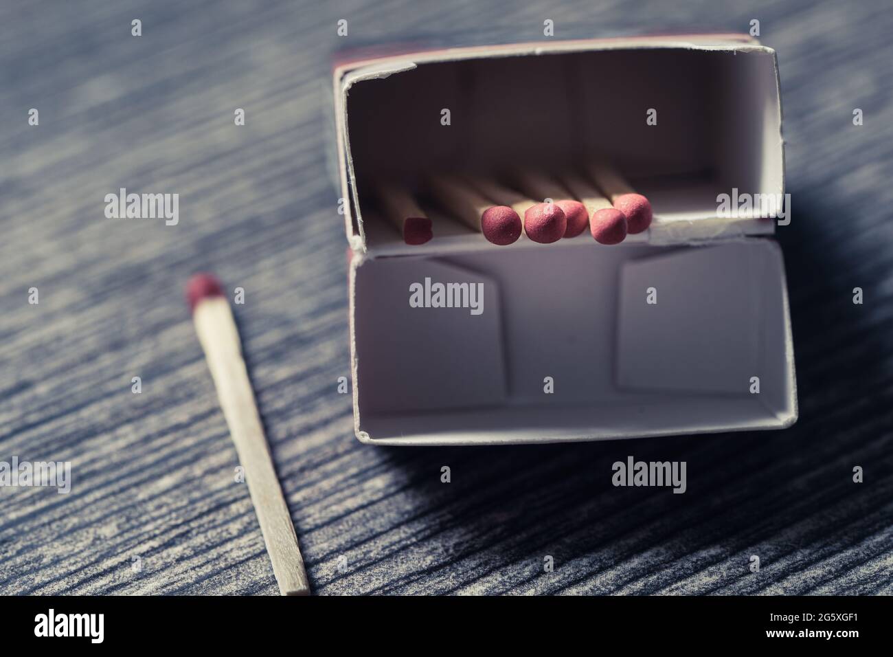 High angle view of matches in a matchbox lying on a wooden table Stock Photo