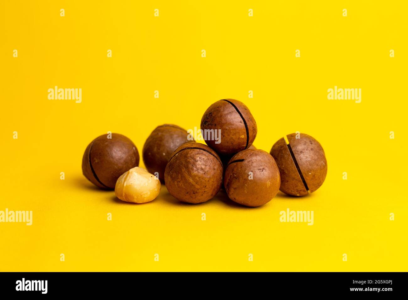 delicious and highcalorie macadamia nut on a yellow background Stock