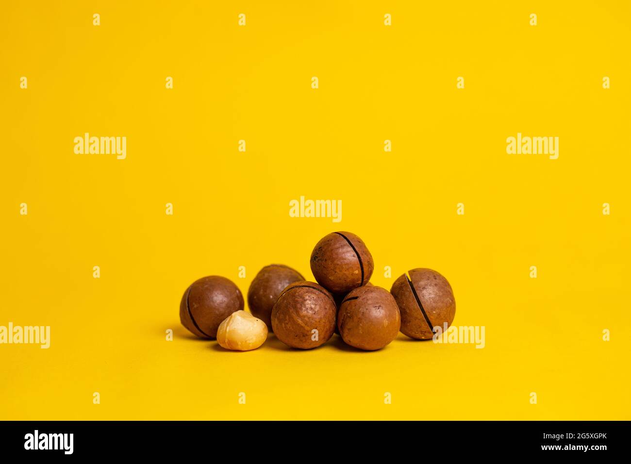 delicious and highcalorie macadamia nut on a yellow background Stock Photo Alamy