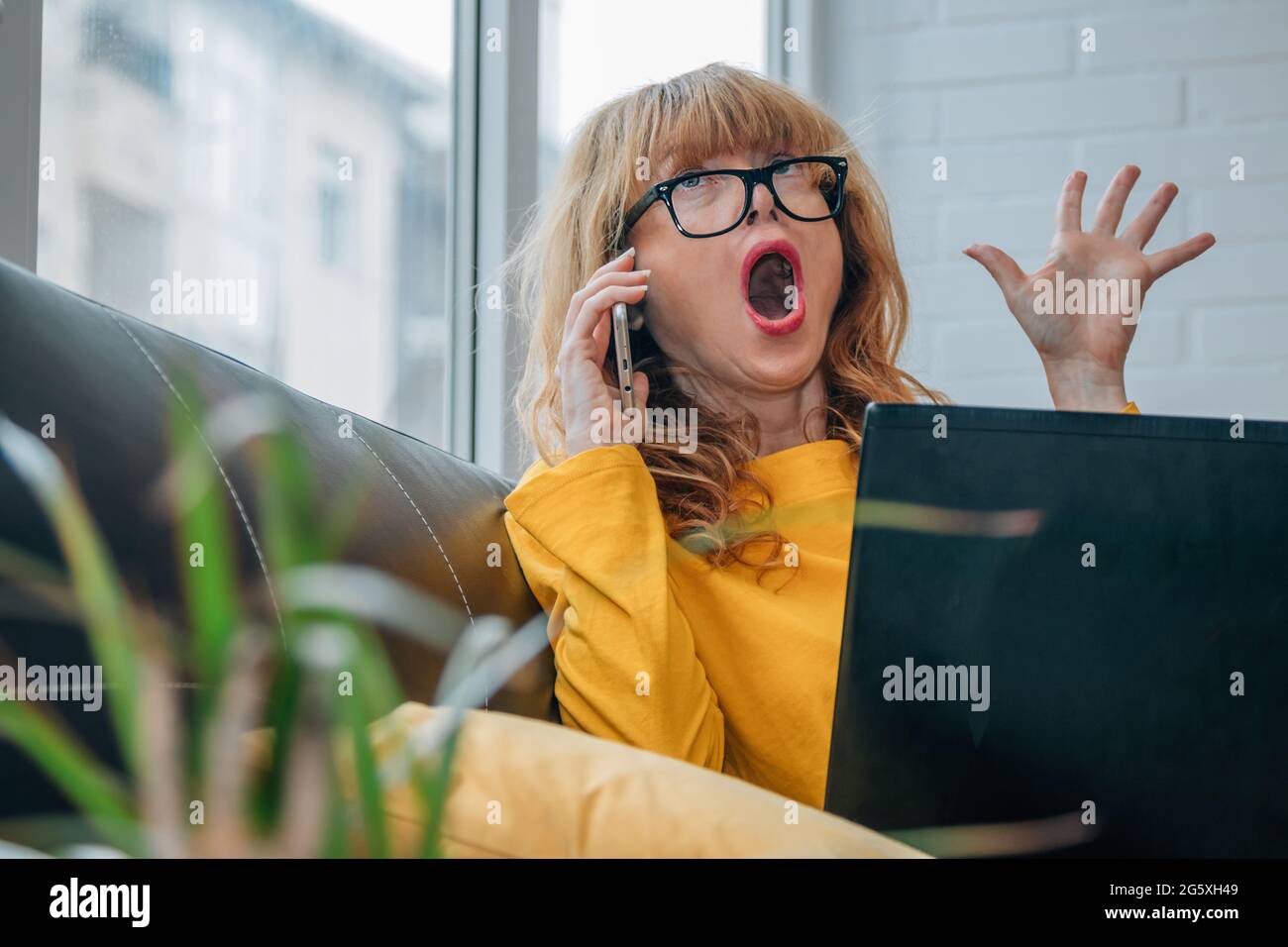 scared woman at home talking on the phone with laptop Stock Photo Alamy