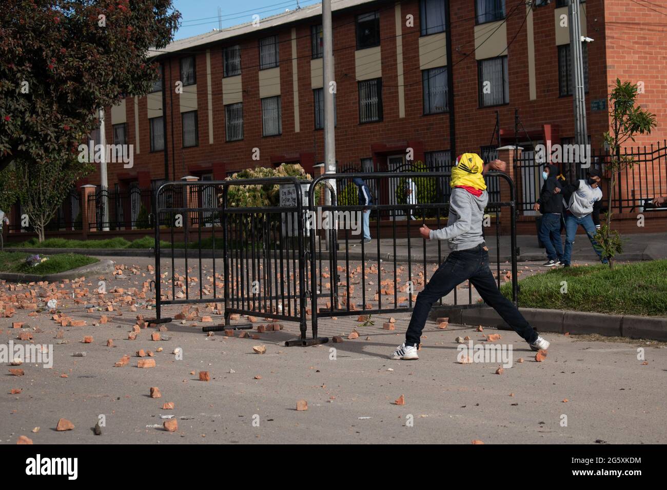 Bogota, Colombia. 29th June, 2021. A demonstrator throws rocks and debree to Colombia's riot police (ESMAD) as people of Fontanar - Suba in Bogota, Colombia protested and clashed against Colombia's riot police (Escuadron Movil Antidisturbios ESMAD) against the visit of Colombia's president Ivan Duque Marquez to a park were Bogota's metro system will be built, amidst two months of anti-government protests against president Ivan Duque Marquez, inequalities and police unrest during the protests, on June 29, 2021. Credit: Long Visual Press/Alamy Live News Stock Photo