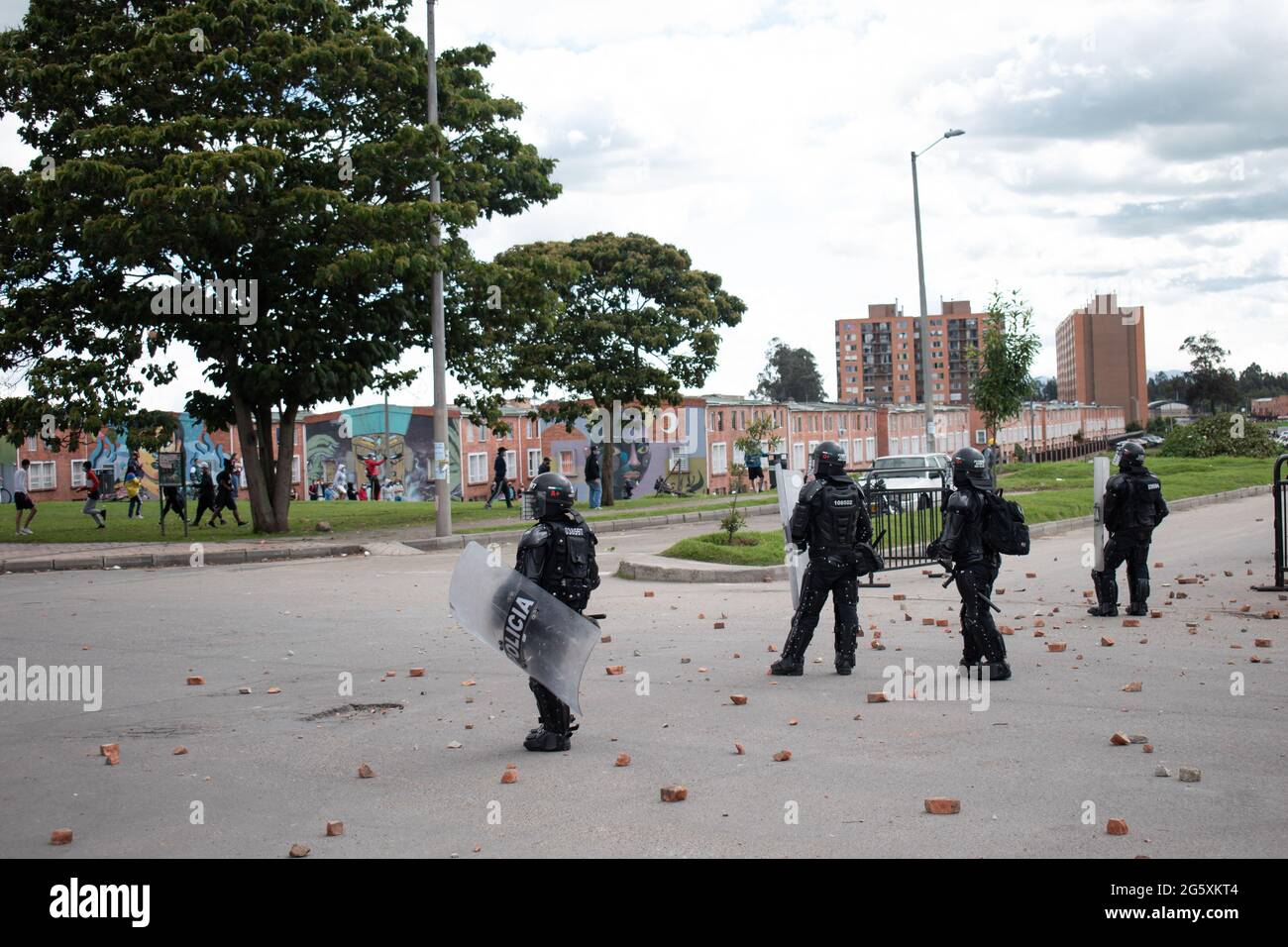 Colombia's riot police officers (ESMAD) use police batons, tear gas canisters and flashbang grendandes, stunt grenades, as people of Fontanar - Suba in Bogota, Colombia protested and clashed against Colombia's riot police (Escuadron Movil Antidisturbios ESMAD) against the visit of Colombia's president Ivan Duque Marquez to a park were Bogota's metro system will be built, amidst two months of anti-government protests against president Ivan Duque Marquez, inequalities and police unrest during the protests, on June 29, 2021. Stock Photo