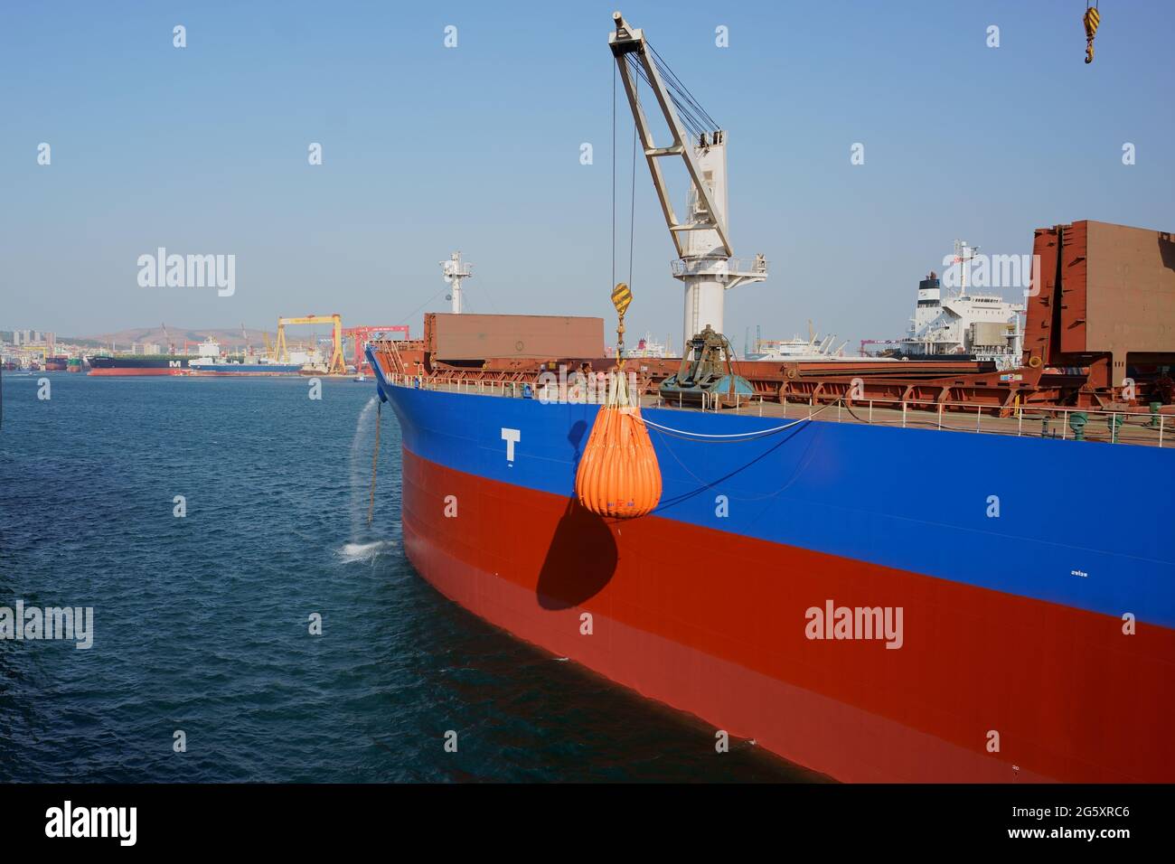 a cargo ship, checking crane wire strength with dummy load during shipyard survey Stock Photo