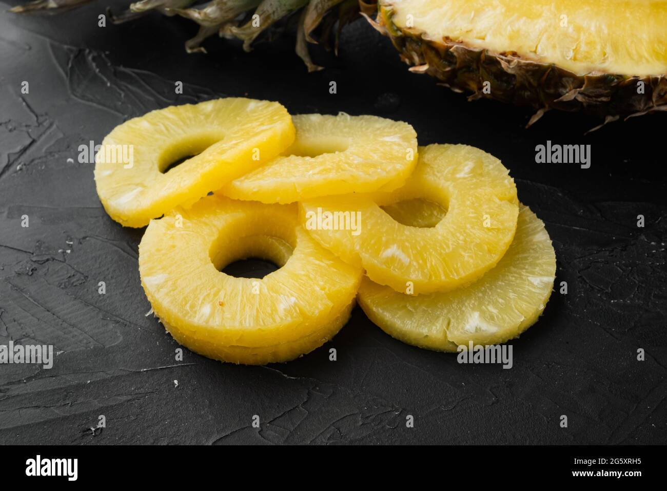 Fresh pineapple slice cuts set, on black dark stone table background Stock Photo