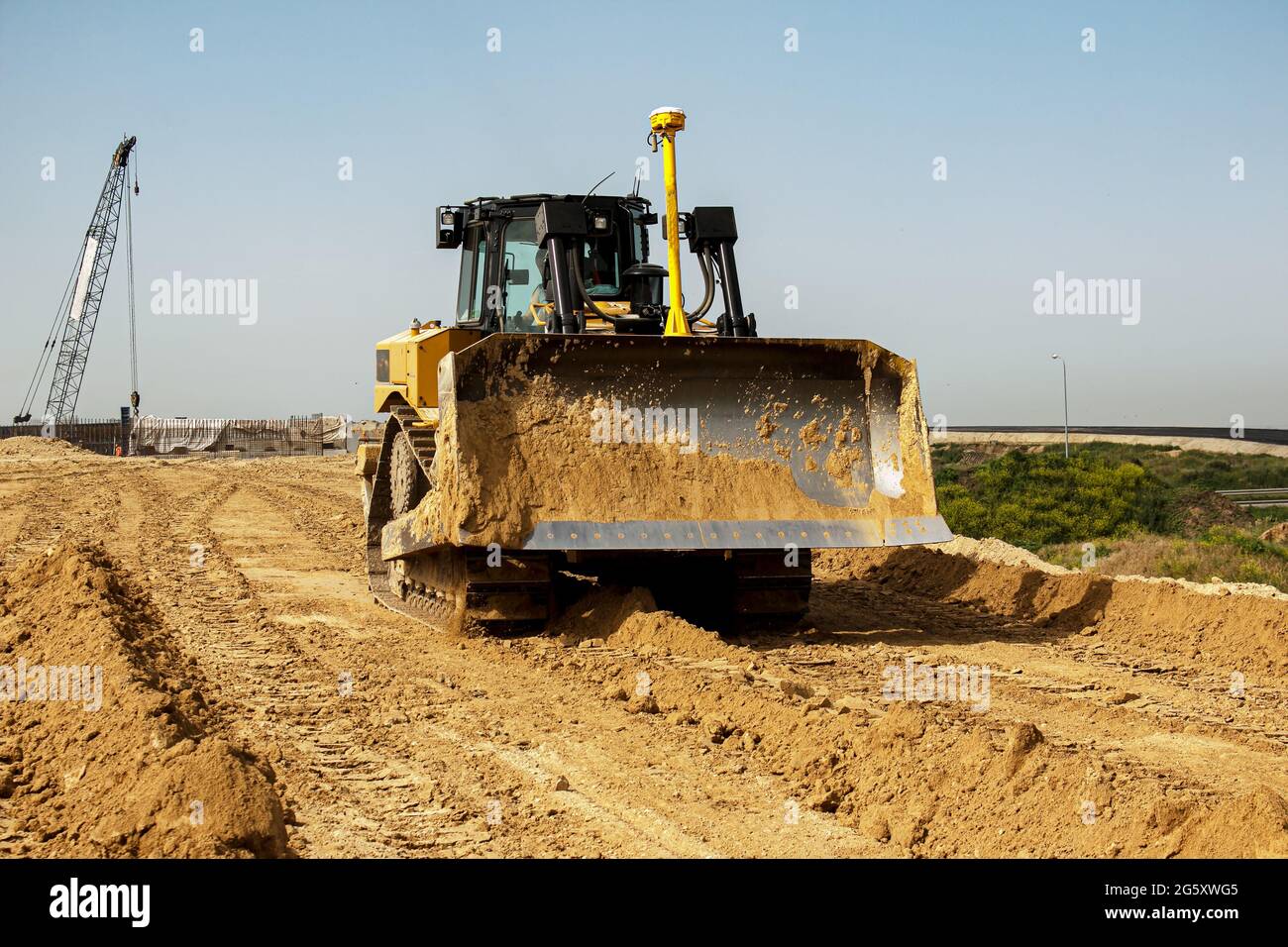 Asphalt road construction process. The bulldozer levels and compacts