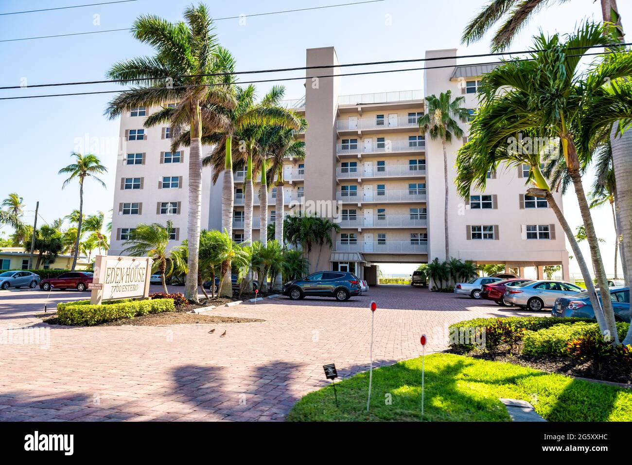Fort Myers Beach, USA - April 29, 2018: Florida gulf coast with hotel condominium apartment building waterfront architecture and palm trees on sunny d Stock Photo