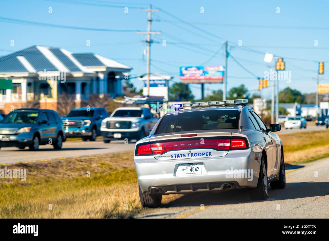 Georgetown, USA - February 3, 2021: Historic city George town in South Carolina with state trooper car on road flashing lights in traffic Stock Photo