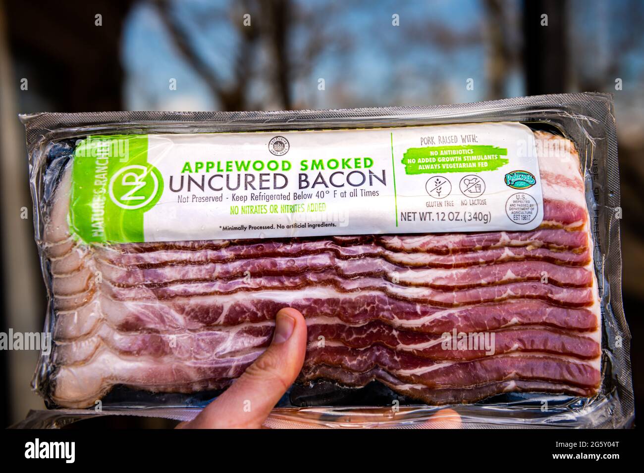Nellysford, USA - April 22, 2021: Raw uncured bacon meat applewood smoked vacuum sealed label sign text packaged by nature's rancher Stock Photo