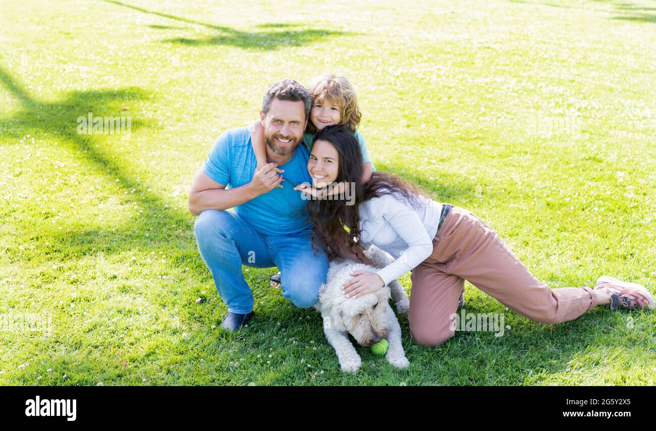 happy parents with kid boy play with dog. mom dad and son love relax ...