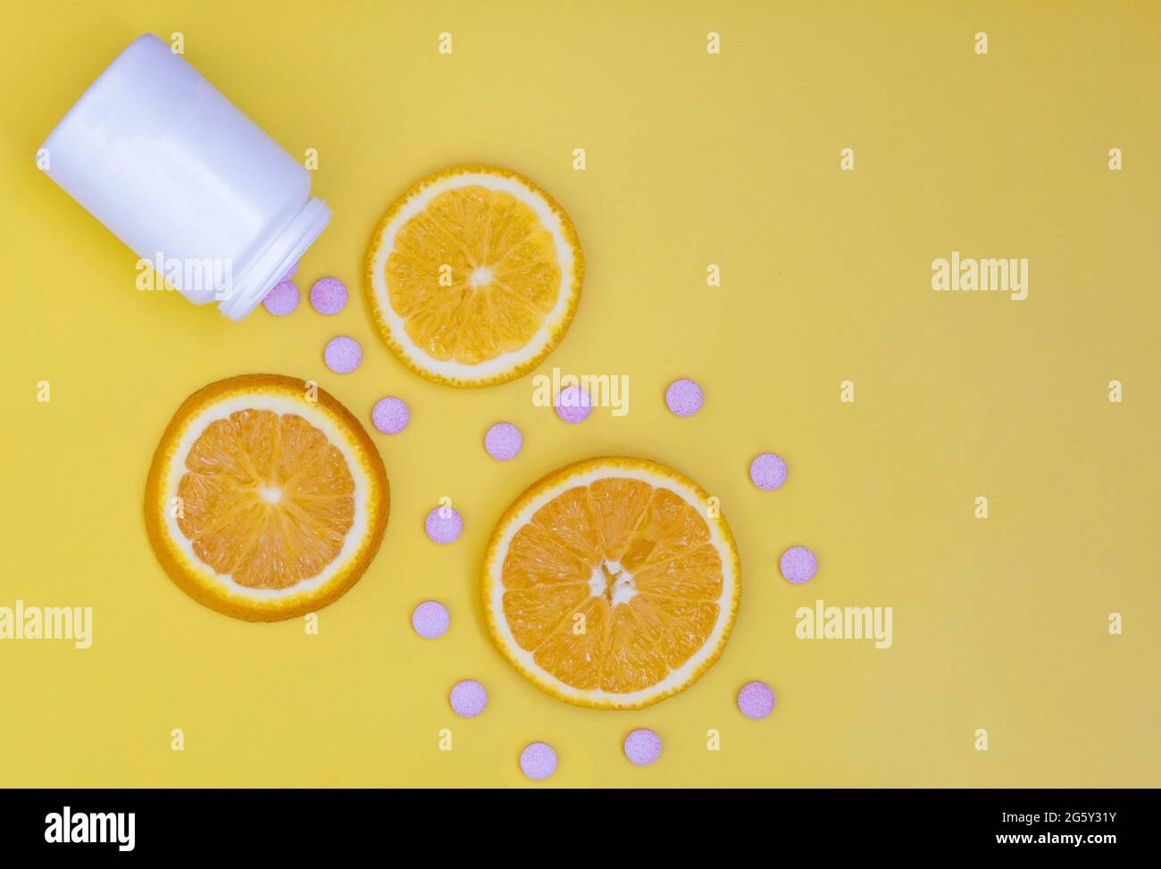 Vitamin C. Orange slices on a bright background and vitamin C tablets. The layout of the branding of a pharmaceutical product.Flat lay. Copy space Stock Photo