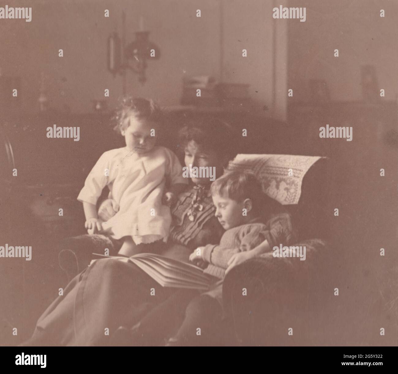 Vintage black and white photo of mother reading to her children 1913. Stock Photo