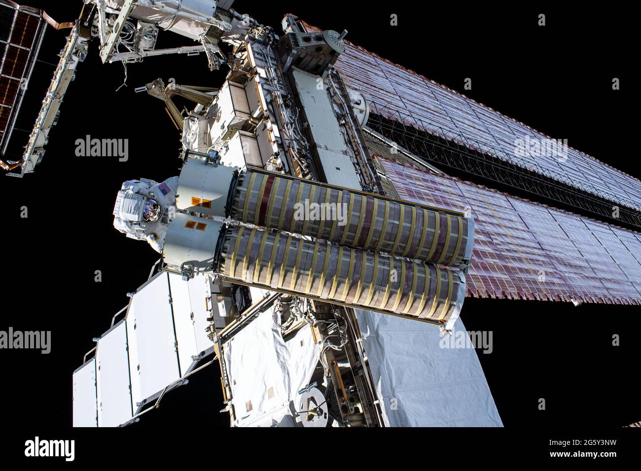 NASA astronaut Shane Kimbrough carries the second roll out solar array for installation on the International Space Station June 25, 2021 in Earth Orbit. Stock Photo