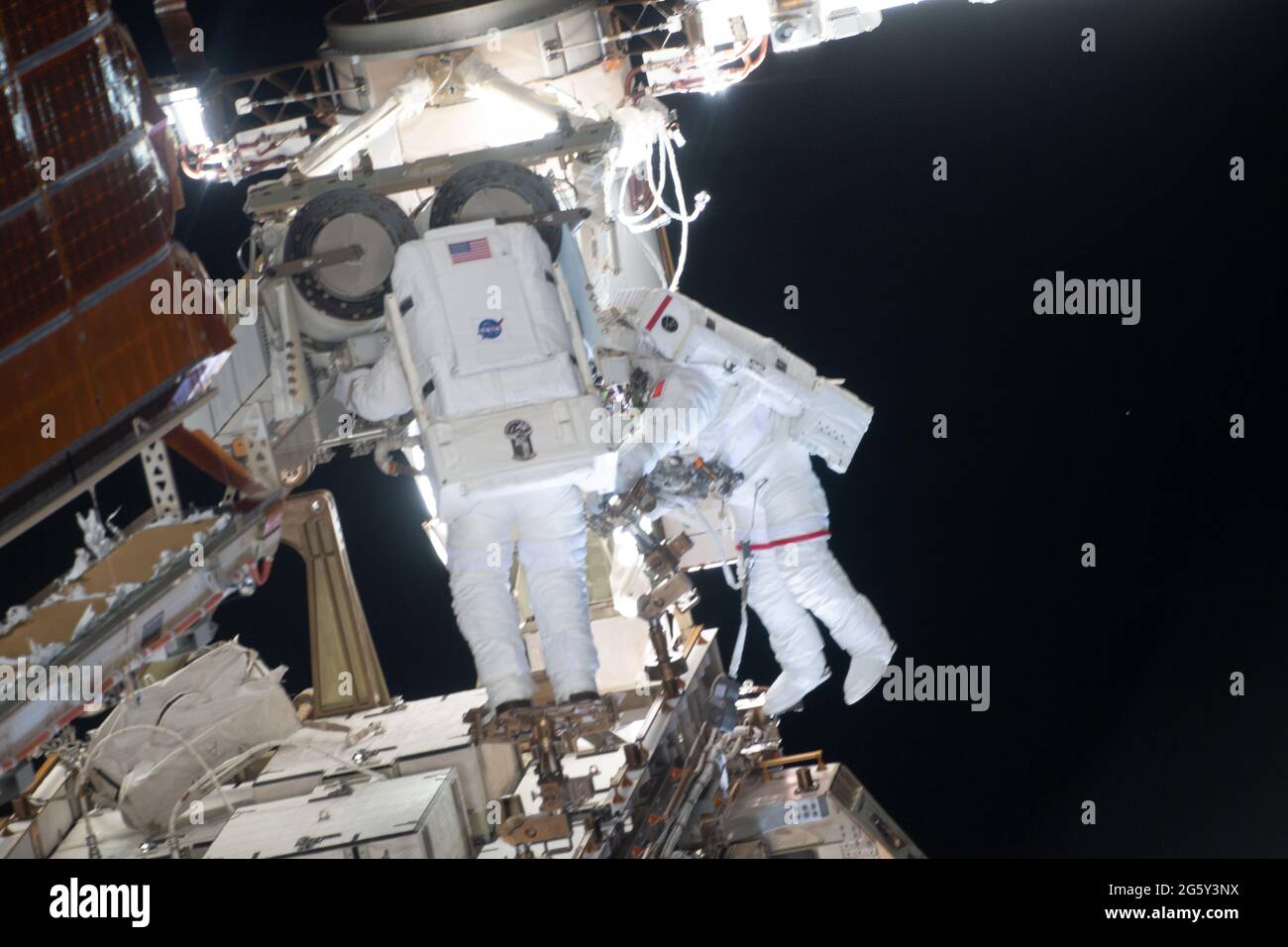 NASA astronaut Shane Kimbrough and ESA astronaut Thomas Pesquet, right, work on the installation of the second roll out solar array on the International Space Station June 25, 2021 in Earth Orbit. Stock Photo