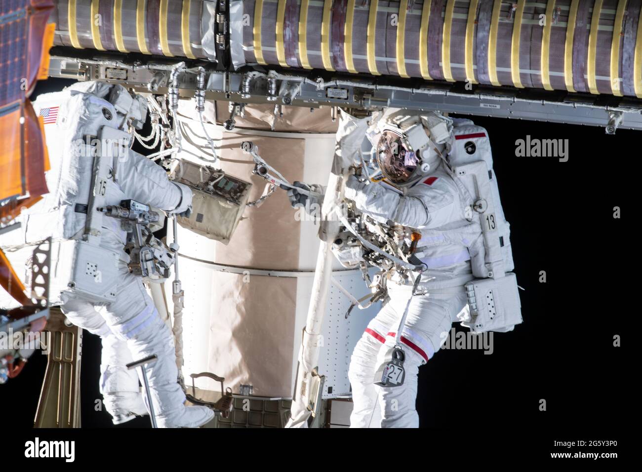 ESA astronaut Thomas Pesquet, right, and NASA astronaut Shane Kimbrough work on the installation of the second roll out solar array on the International Space Station June 25, 2021 in Earth Orbit. Stock Photo