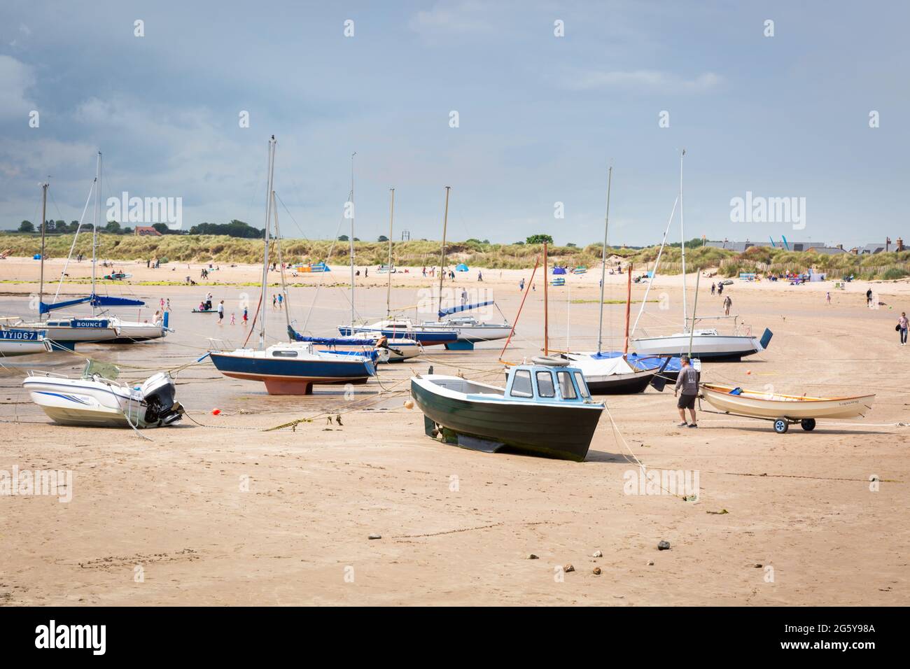 Boats on the beach at low tide, Beadnell Bay, Northumberland, UK Stock Photo