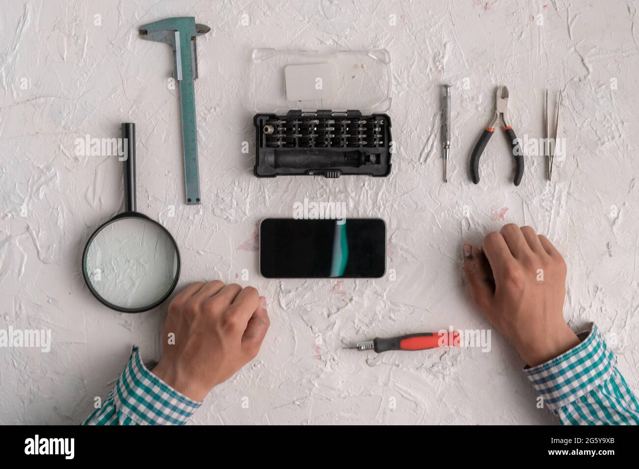 master with tools repair the broken smartphone in the workshop Stock Photo
