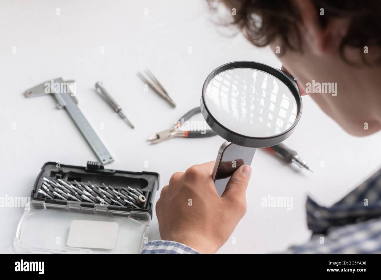 master with tools repair the broken smartphone in the workshop Stock Photo