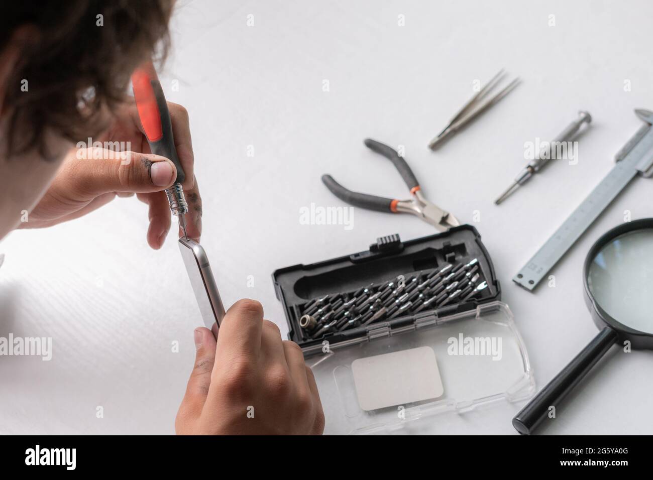 master with tools repair the broken smartphone in the workshop Stock Photo