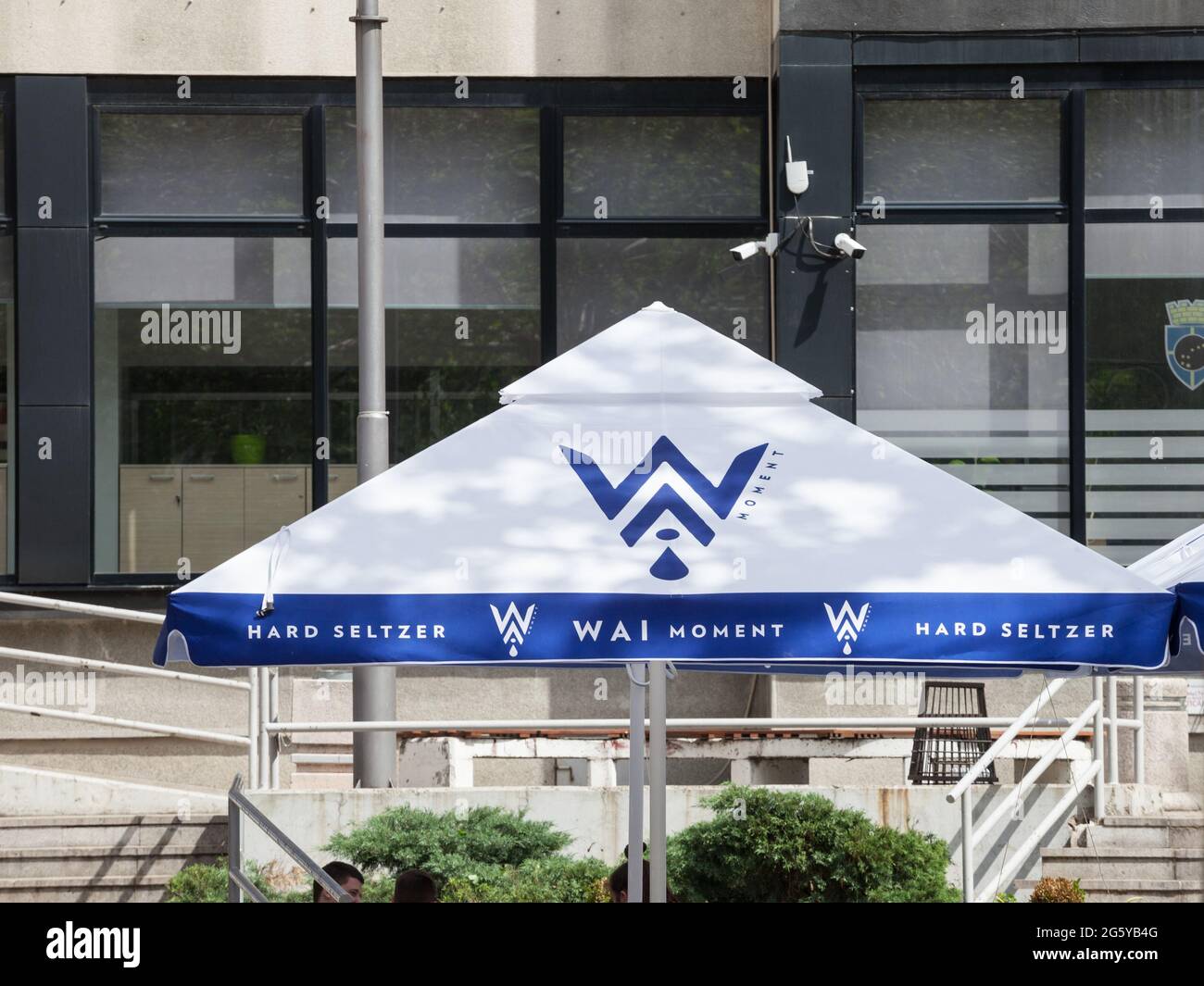 Picture of an umbrella with the logo of Wai Moment in Belgrade, Serbia. Wai Moment is a hard seltzer with a four-percent alcohol content. It uses natu Stock Photo