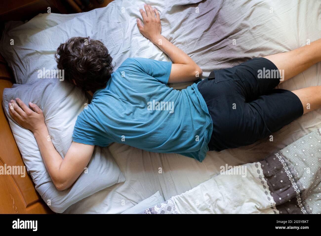 person's wrong position during the sleep in bed, bad posture Stock Photo