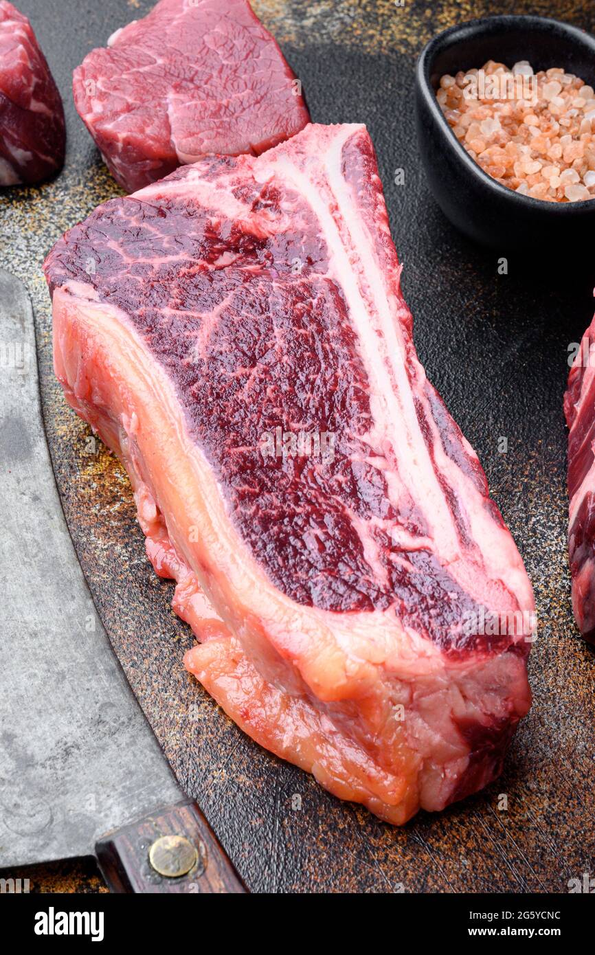 Thick fatty marbled raw beef club steak set, on old dark rustic