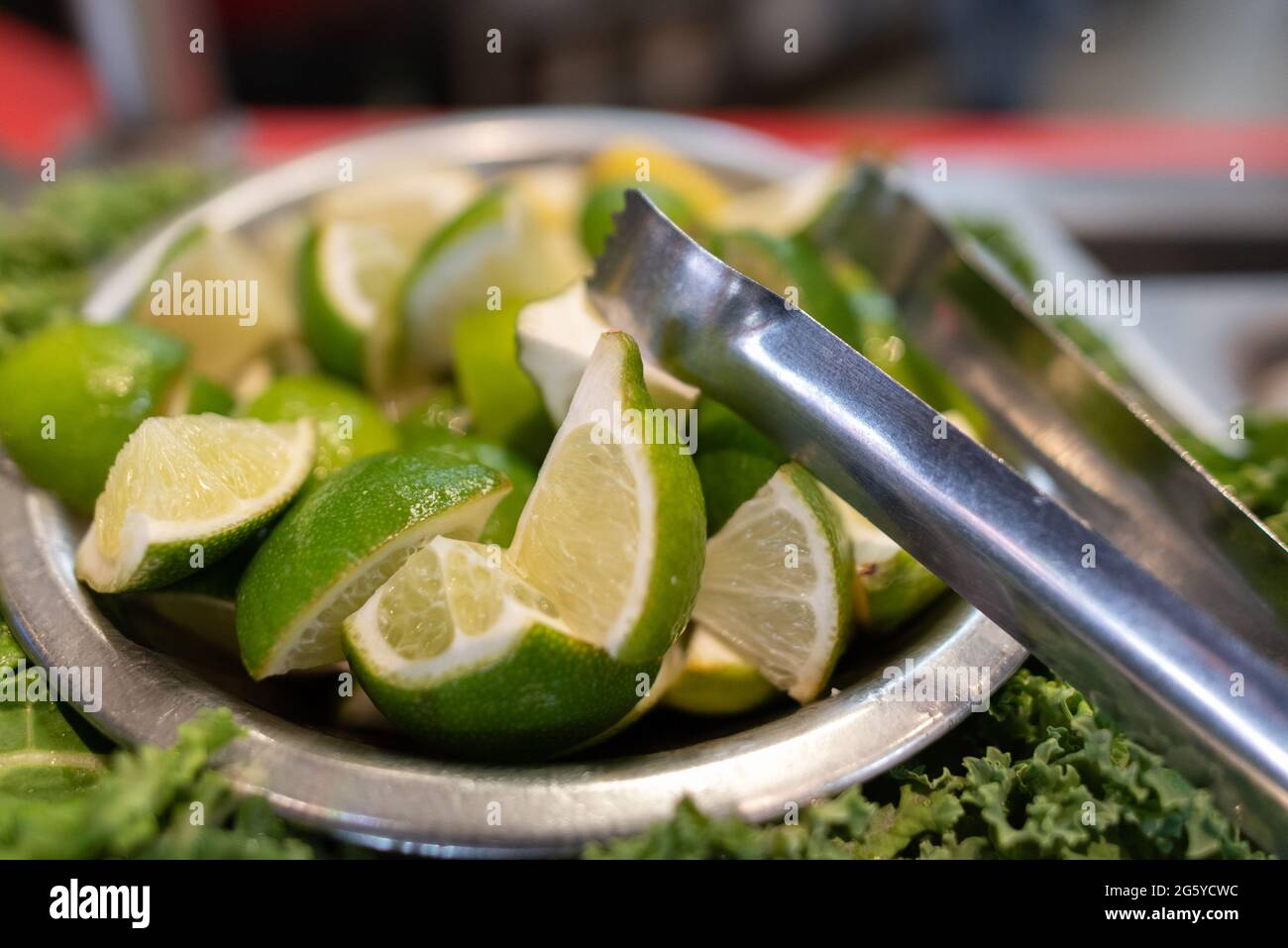 Lime slices cut into quarters and served with tongs to add to your