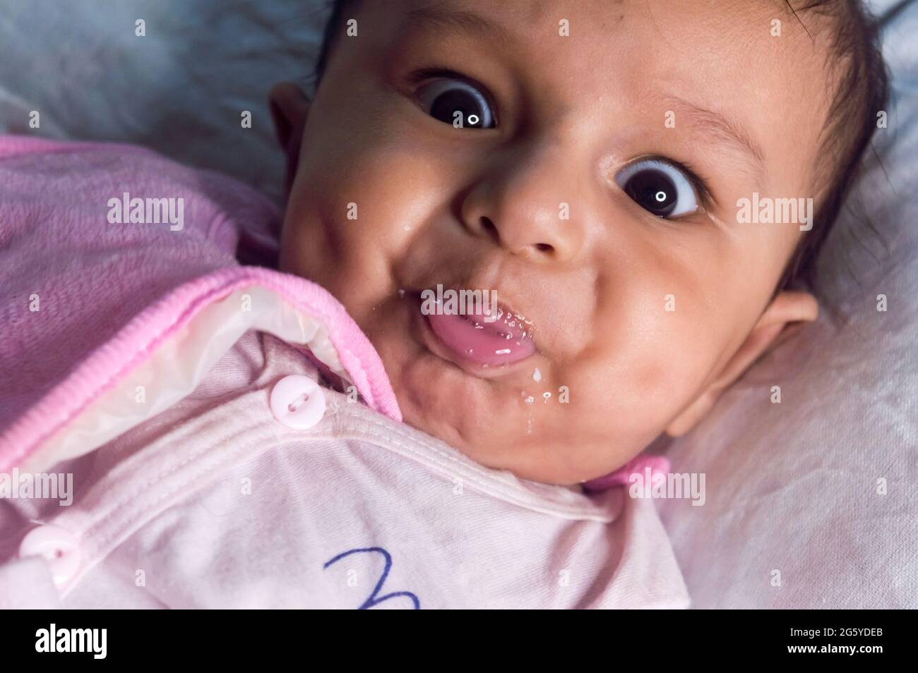 Cute baby boy wearing Baby Bib with dimple in face bubbles from mouth and  looking at camera. Sweet little infant toddler Closeup portrait. Indian  ethn Stock Photo - Alamy