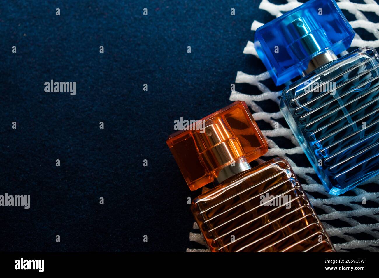 Glass orange bottle and a blue bottle lotion on a blue surface Stock Photo