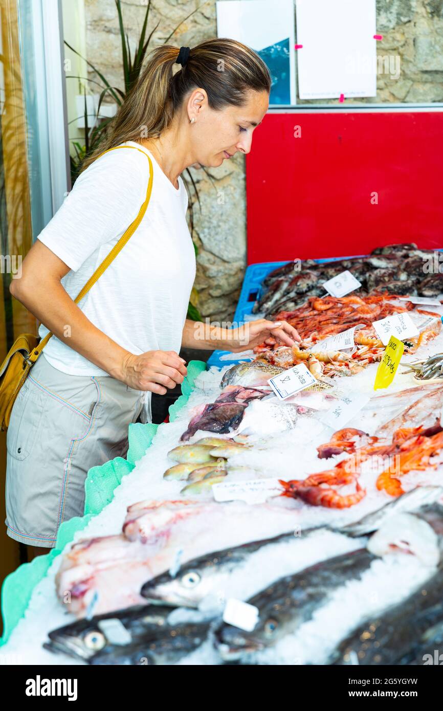 Woman choosing seafood at fish shop Stock Photo - Alamy