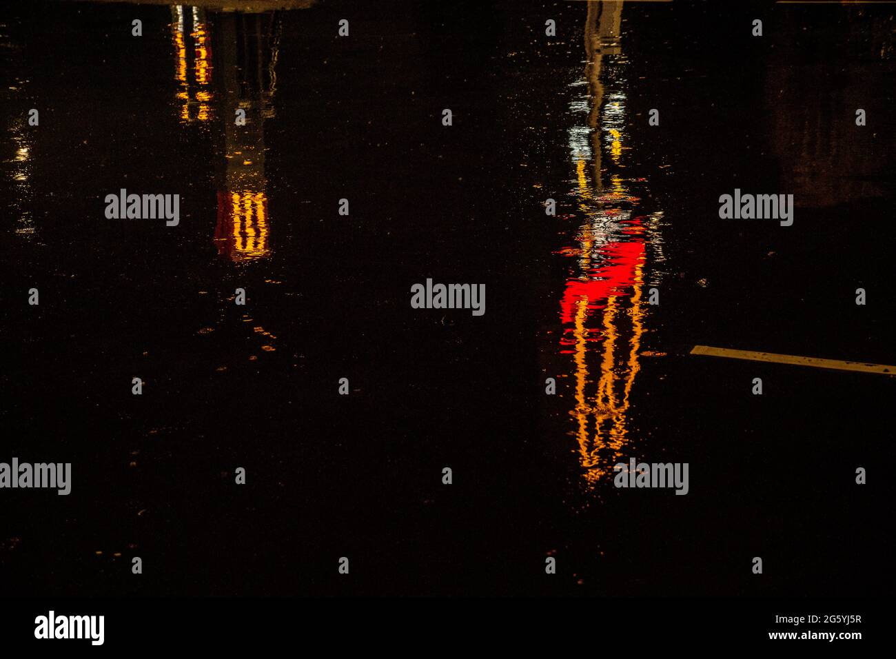 Distorted reflection of a McDonalds sign in puddles at night Stock Photo
