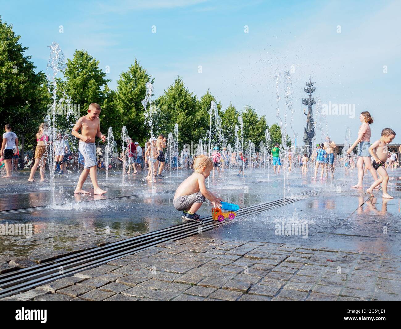 Moscow, Russia, June 26, 2021. Children bathe in the jets of a fountain in the Muzeon Park. Water entertainment for the townspeople on a hot summer day. Stock Photo
