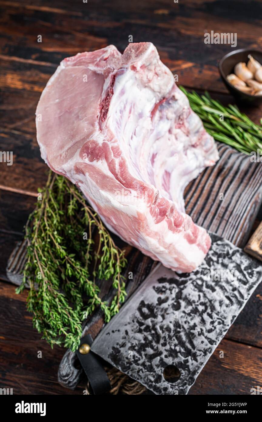 Raw rack of pork loin chops with ribs on a butcher board with meat ...