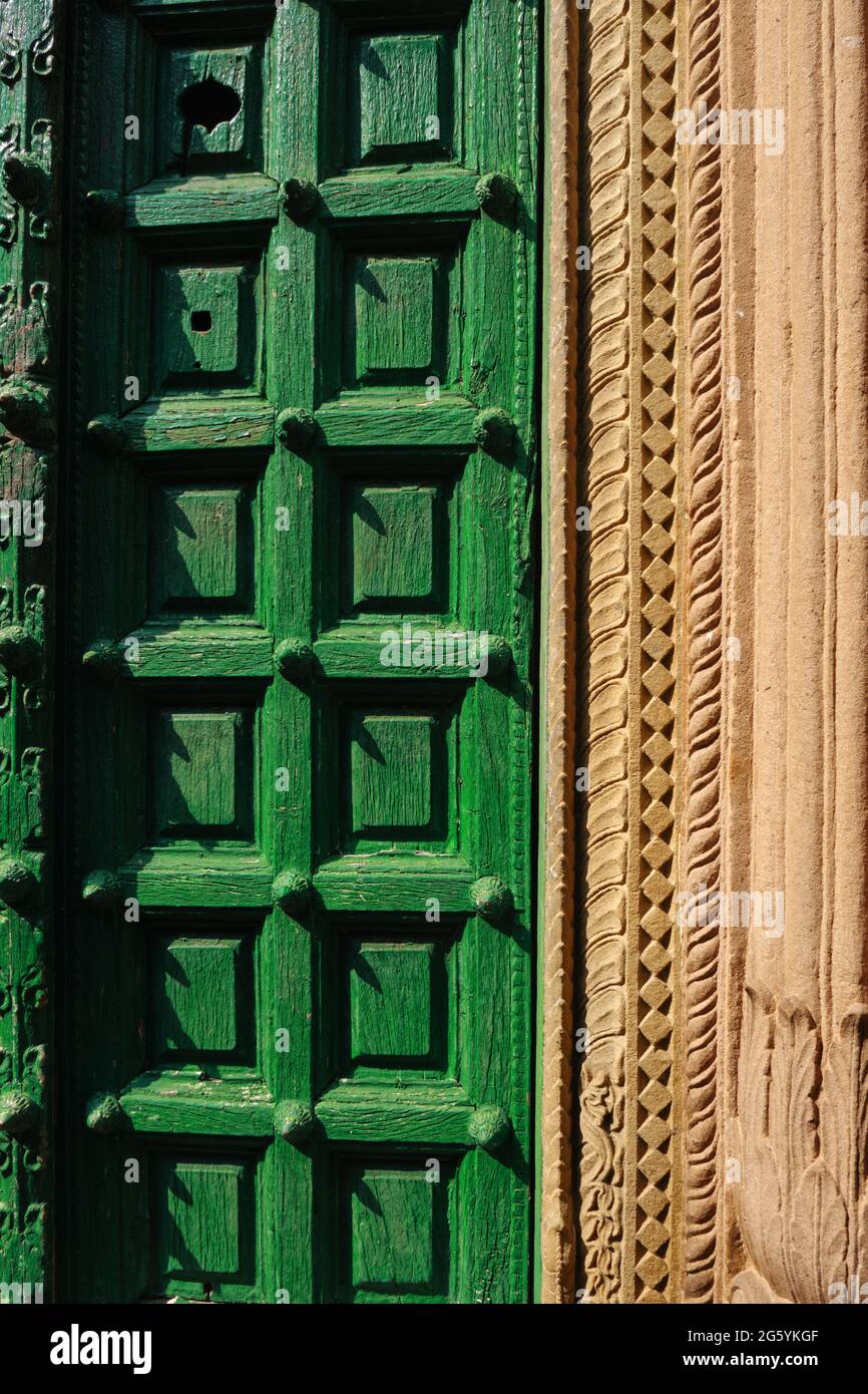 Old wooden green door with designer wall at varanasi (India) street Stock Photo
