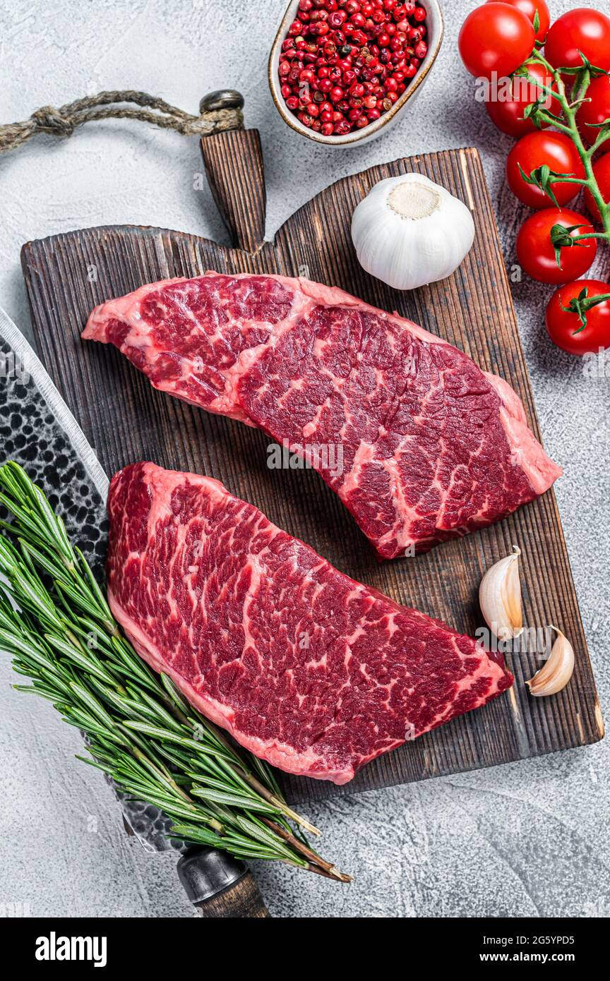 Raw denver cut black angus organic steak on a butcher cutting board