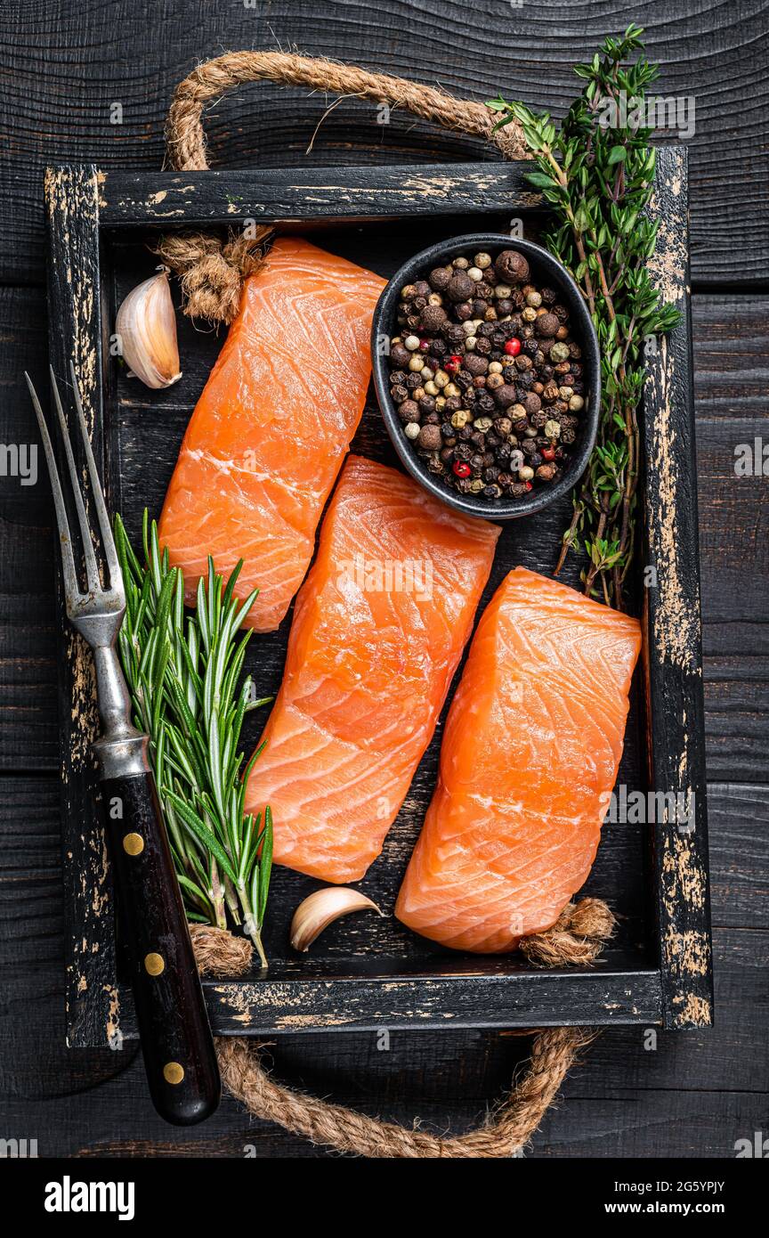 Raw salmon fillet fish steaks in a wooden tray with thyme and rosemary ...