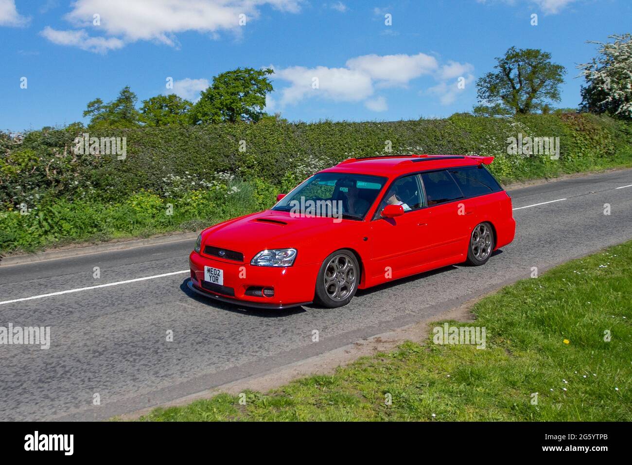 2002 red Subaru Legacy estate 1990 cc petrol 5dr, en-route to Capesthorne Hall classic May car show, Cheshire, UK Stock Photo