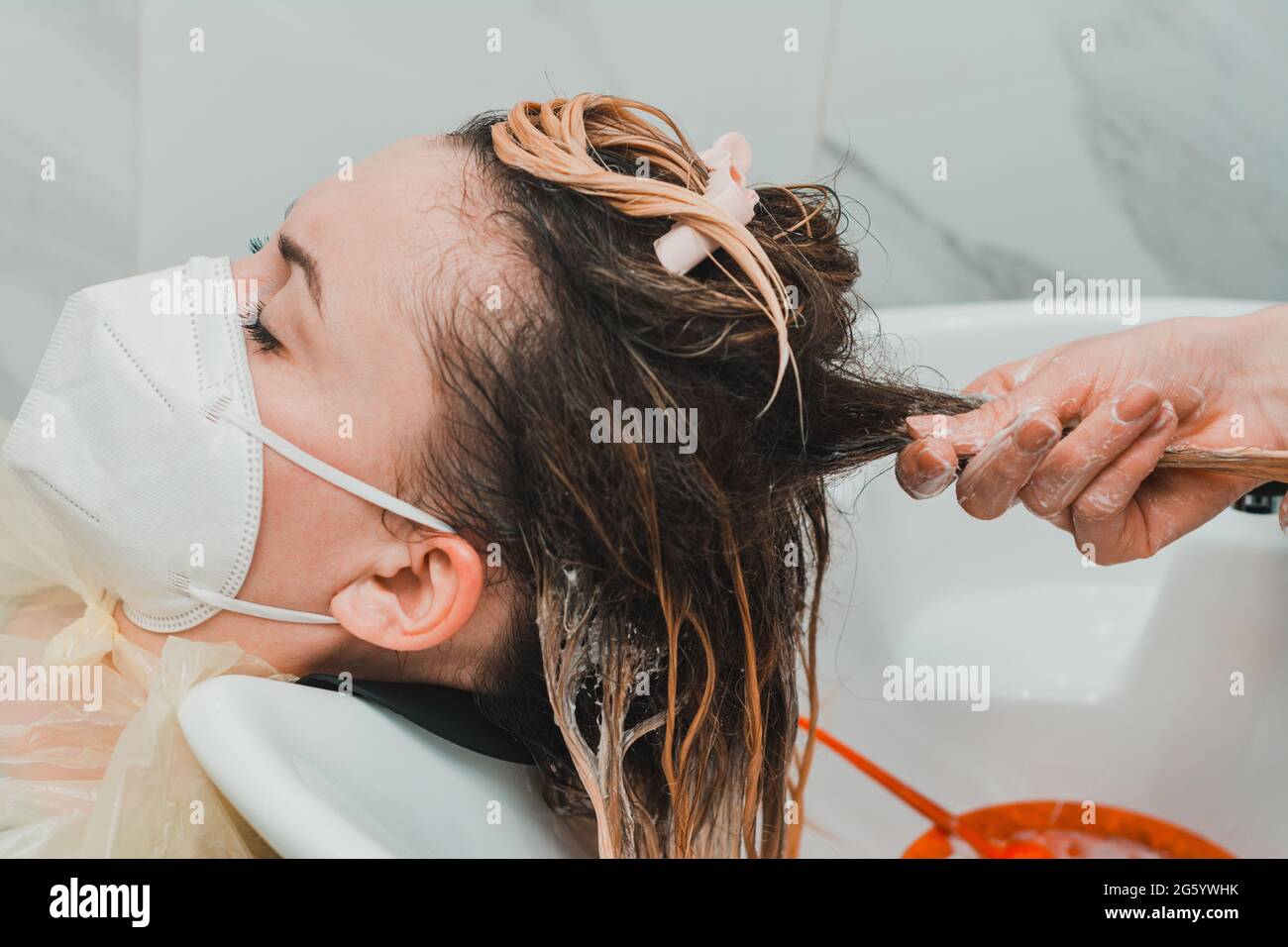 Applying conditioner after shampoo, hair care in the salon, balayage