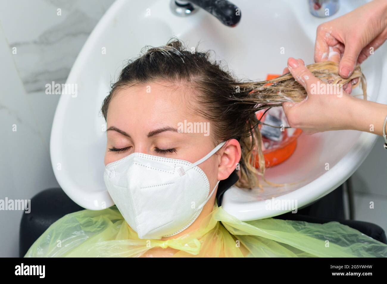 Applying conditioner after shampoo, hair care in the salon, balayage