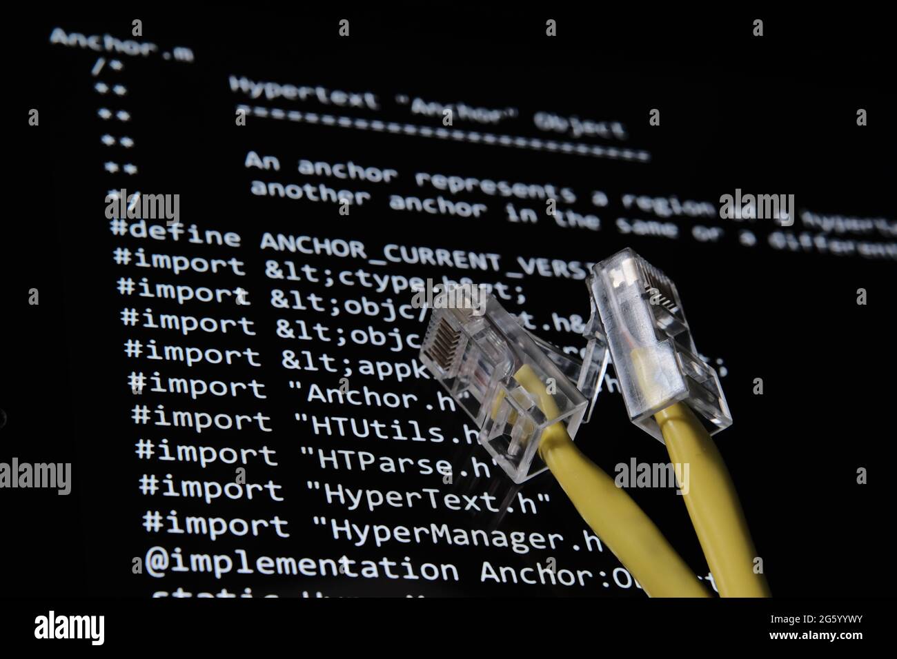 Internet cable and World Wide Web source code which was sold as NFT by Tim Berners Lee seen on the blurred background screen. Concept. Stafford, UK, J Stock Photo
